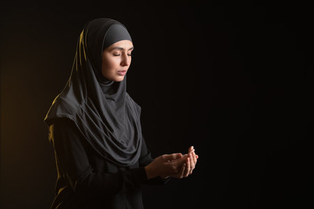 Praying Muslim woman on dark backgroundの写真素材