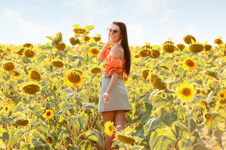 beautiful young woman in sunflower fieldの写真素材