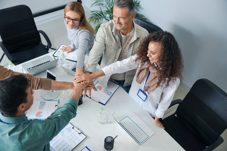 Team of business people putting hands together in officeの写真素材