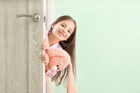 Cute little girl looking out the doorの写真素材