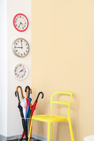 Different clocks hanging on color wall in roomの写真素材