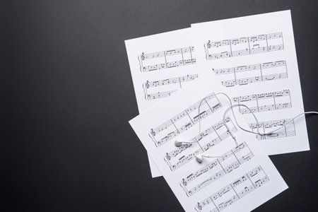 Music sheets and earphones on dark backgroundの写真素材