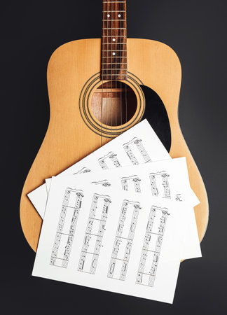 Music sheets and guitar on dark backgroundの写真素材