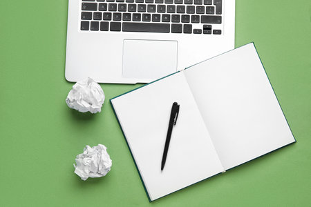 Open book, pen, crumpled paper and laptop on color background. World Poetry Day celebration