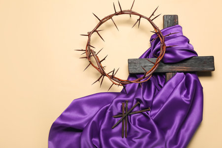 Cross with purple fabric, nails and crown of thorns on beige background. good friday conceptの写真素材