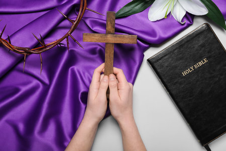 Woman praying with wooden cross on light background. good friday conceptの写真素材