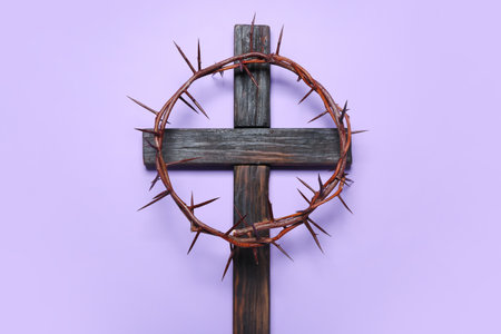 Wooden cross with crown of thorns on lilac background. good friday conceptの写真素材