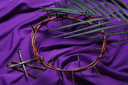 Crown of thorns with nails and palm leaf on purple fabric background. good friday conceptの写真素材