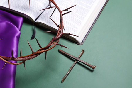 Crown of thorns with nails and Holy Bible on green background, closeup. good friday concept