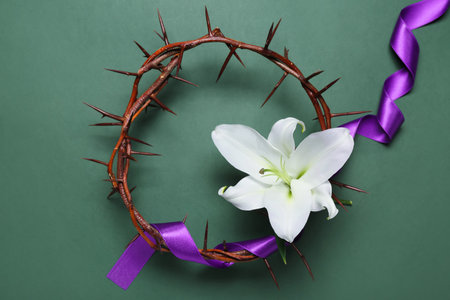Crown of thorns with purple ribbon and lily flower on green background. good friday conceptの写真素材