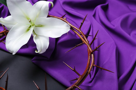 Crown of thorns with lily flower and purple fabric on dark background, closeup. good friday conceptの写真素材