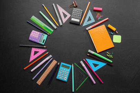 Frame made of different stationery on dark background. Pi day celebration