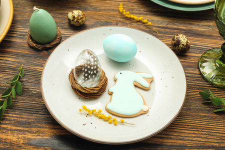Table setting with Easter eggs, bunny and mimosa flowers on brown wooden background