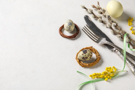 Composition with cutlery, Easter eggs, pussy willow branches and mimosa flowers on white background