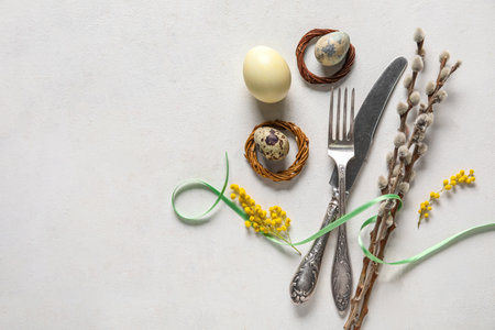 Composition with cutlery, Easter eggs, pussy willow branches and mimosa flowers on white background