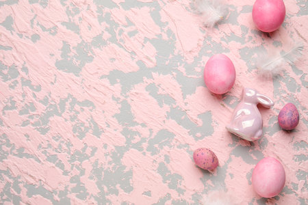 Easter eggs with rabbit and feathers on pink grunge backgroundの写真素材