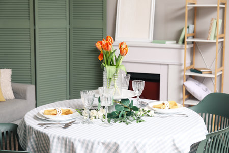 Dining table with setting for International Women's Day celebration and flowers in living roomの写真素材