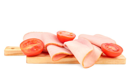 Board with tasty slices of ham and tomatoes isolated on white background
