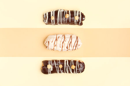 Tasty glazed eclairs on yellow and orange backgroundの写真素材