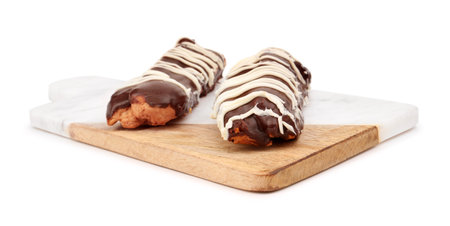 Board with sweet chocolate eclairs isolated on white background