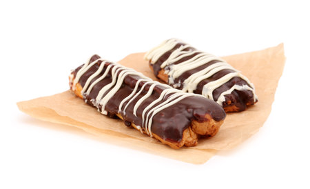 Parchment with sweet chocolate eclairs isolated on white background
