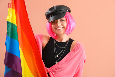 Young woman with LGBT flag on pink background