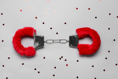 Handcuffs from sex shop and hearts on gray backgroundの写真素材