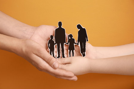 Hands of family with human figures on color backgroundの写真素材