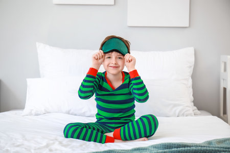 Little boy sleeping mask on bed at homeの写真素材