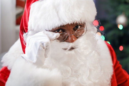 African-American Santa Claus in room decorated for Christmas