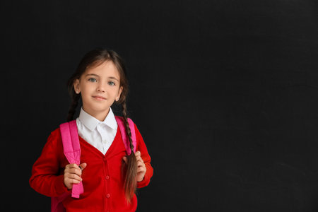Little school girl on dark backgroundの写真素材
