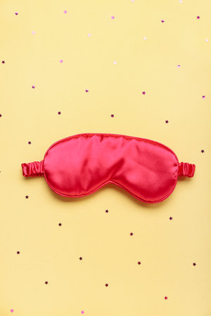Composition with sleeping mask and confetti on yellow background. World Sleep Day conceptの写真素材