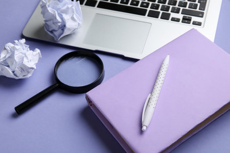 Composition with book, pen, magnifier, crumpled paper balls and laptop on color background, closeup. World Poetry Day celebrationの写真素材