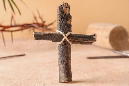 Wooden cross with nails on beige background, closeup. good friday conceptの写真素材
