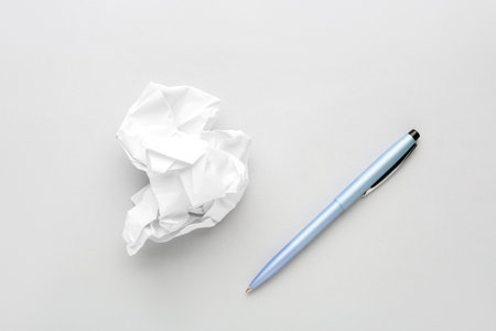 Crumpled paper and pen on light backgroundの写真素材