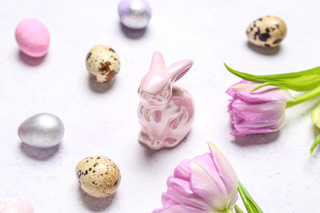 Bunny, Easter quail eggs and tulip flowers on white background