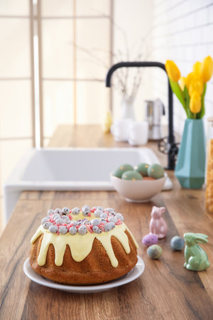 Easter cake with painted eggs and bunnies on kitchen counterの写真素材