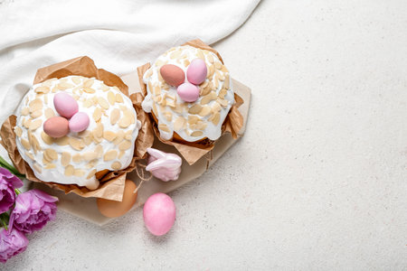 Easter cakes with painted eggs and tulip flowers on white grunge background