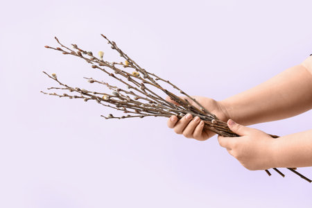 Woman holding willow branches on lilac backgroundの写真素材