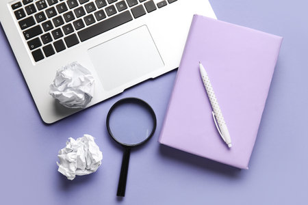 Composition with book, pen, magnifier, crumpled paper balls and laptop on color background. World Poetry Day celebrationの写真素材