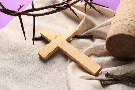Crown of thorns with cross, nails, mallet and shroud on lilac background, closeup. good friday conceptの写真素材