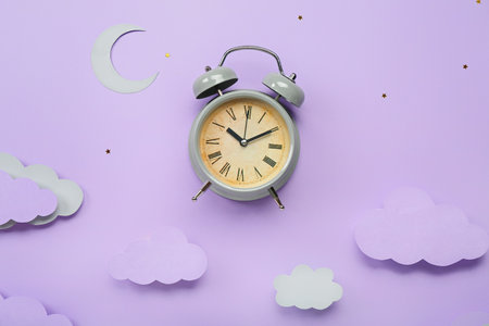Composition with alarm clock and paper decor on color background. World Sleep Day concept