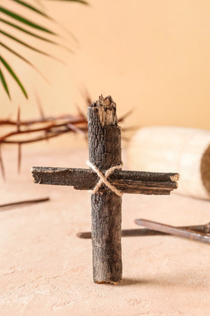 Wooden cross with nails on beige background, closeup. good friday conceptの写真素材