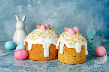 Easter cake, painted eggs and bunnies on blue grunge background