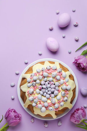 Composition with tasty Easter cake, eggs, candies and tulip flowers on color backgroundの写真素材