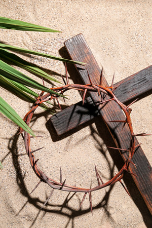 Crown of thorns with wooden cross and palm leaf on sand. good friday conceptの写真素材