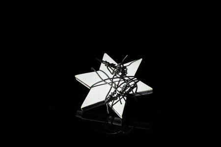 Star with barbed wire on dark background.