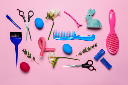 Hairdressing accessories with Easter eggs, rabbit and flowers on pink backgroundの写真素材