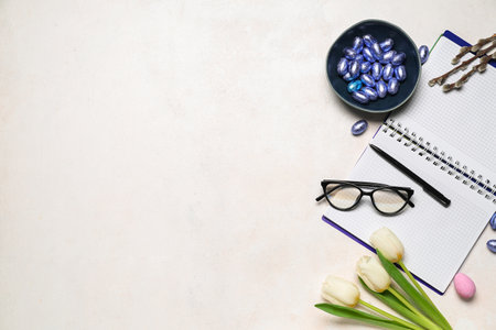 Notebook with eyeglasses, Easter eggs and tulips on white backgroundの写真素材