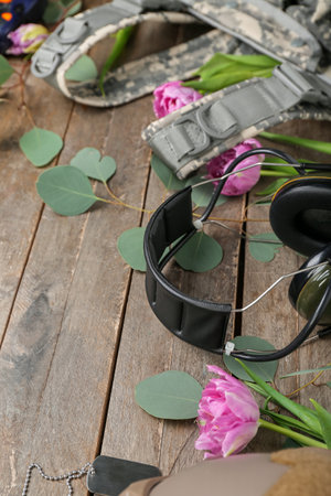 Military equipment with tulips and eucalyptus on wooden background, closeup. hello springの写真素材